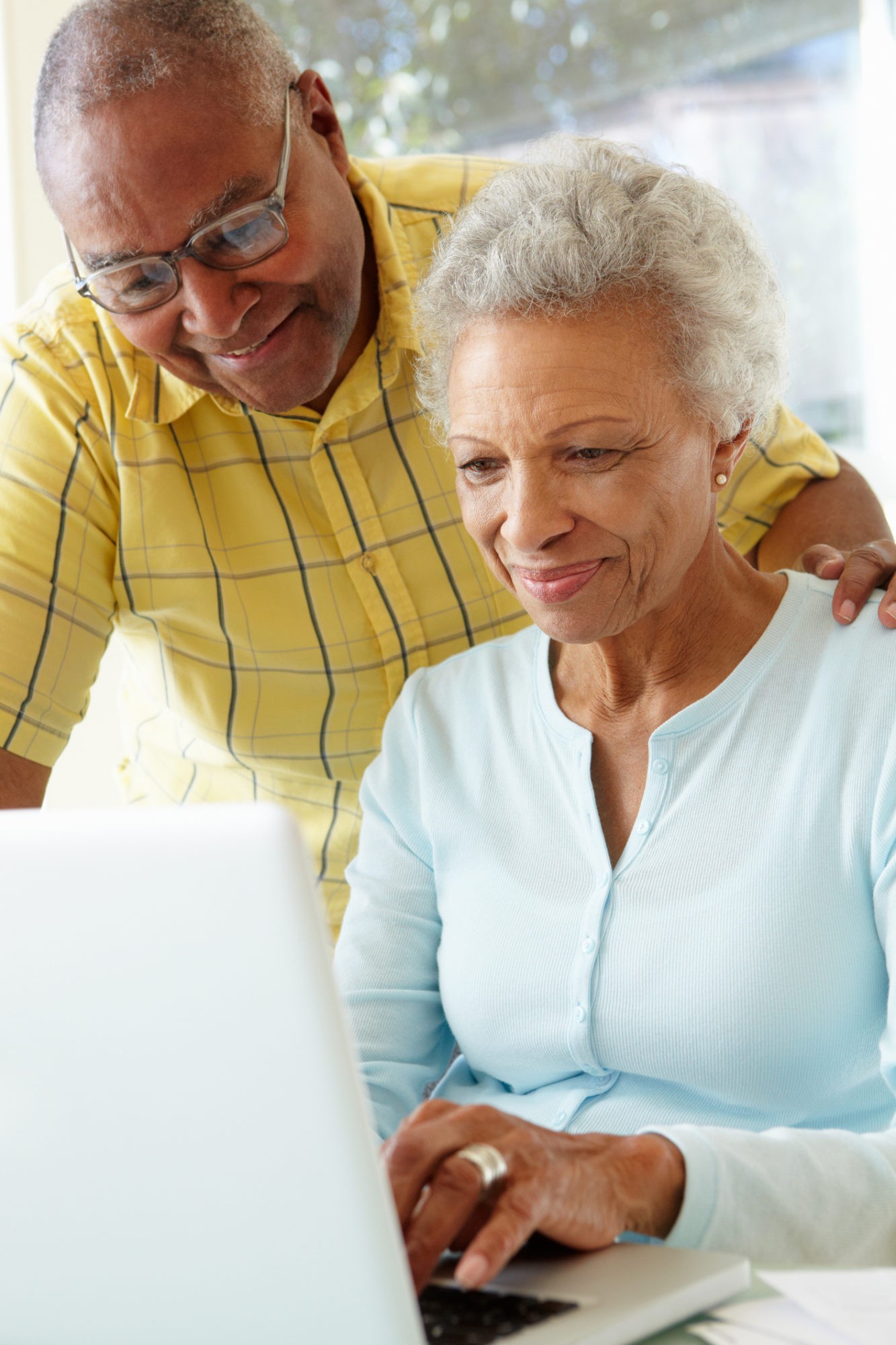 Senior Couple Using Laptop At Home Looking Down